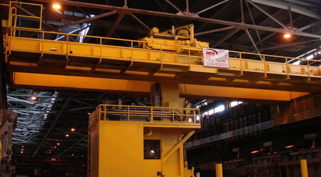 Ace double girder overhead bridge crane with operator cab in steel mill.
